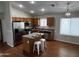 Well-lit kitchen with stainless steel appliances, wood cabinets, island, and hardwood floors at 41580 W Sunland Dr, Maricopa, AZ 85138