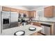 Well-lit kitchen featuring stainless steel appliances, light countertops, and wood cabinets at 41580 W Sunland Dr, Maricopa, AZ 85138