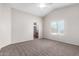 Spacious main bedroom with carpet flooring, a ceiling fan, and an ensuite bathroom at 41580 W Sunland Dr, Maricopa, AZ 85138