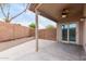 Covered patio with a ceiling fan, concrete floor and block fence surrounding the yard at 41580 W Sunland Dr, Maricopa, AZ 85138