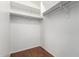 A walk-in closet with white shelving and clothing rods, complemented by wood floors at 41580 W Sunland Dr, Maricopa, AZ 85138