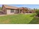 A spacious backyard with green grass, a covered patio, an outdoor kitchen, and privacy walls at 4364 S Tatum Ln, Gilbert, AZ 85297