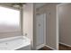 Bathroom featuring a white bathtub, glass-door shower and a window for natural light at 4364 S Tatum Ln, Gilbert, AZ 85297