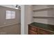 Bedroom with tan walls, a window and a view of a wooden cabinet and shelf in an adjoined room at 4364 S Tatum Ln, Gilbert, AZ 85297