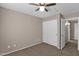 Neutral bedroom featuring a ceiling fan, carpeted floor, and white closet doors at 4364 S Tatum Ln, Gilbert, AZ 85297