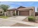 Tan single-story home with a brown roof, a two-car garage, and low-maintenance landscaping at 4364 S Tatum Ln, Gilbert, AZ 85297