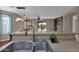 Kitchen featuring stainless steel sink, and a view of living area and outdoor patio at 4364 S Tatum Ln, Gilbert, AZ 85297