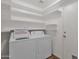 Bright laundry room with white washer and dryer, shelving and a door to the exterior at 4364 S Tatum Ln, Gilbert, AZ 85297