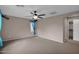 Spacious main bedroom with plush carpet, a ceiling fan, one window, and a doorway to the ensuite at 4364 S Tatum Ln, Gilbert, AZ 85297