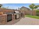 Outdoor kitchen featuring stainless steel grill, mini refrigerator, and brick accents at 4364 S Tatum Ln, Gilbert, AZ 85297