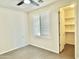 Bedroom with neutral walls, tile floors, plantation shutters on window, and access to closet at 4417 N 156Th Dr, Goodyear, AZ 85395