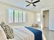 Bright bedroom featuring shuttered windows, ceiling fan, ensuite bathroom, and neutral decor at 4417 N 156Th Dr, Goodyear, AZ 85395