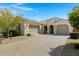 Charming single-story home featuring a tile roof, paver driveway, and a well-manicured front yard at 4417 N 156Th Dr, Goodyear, AZ 85395