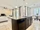 Modern kitchen island featuring a granite countertop, dark cabinets, and stainless steel faucet at 4417 N 156Th Dr, Goodyear, AZ 85395