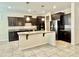 Spacious kitchen featuring a large island, granite counters, dark cabinets, and stainless appliances at 4417 N 156Th Dr, Goodyear, AZ 85395