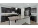 Spacious kitchen with granite countertops, black cabinetry, and a large island at 4417 N 156Th Dr, Goodyear, AZ 85395