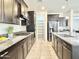 Modern kitchen featuring granite countertops, dark cabinetry, stainless steel appliances, and a convenient island at 4417 N 156Th Dr, Goodyear, AZ 85395