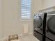 Well-lit laundry room with modern appliances, window, and built-in shelving for storage at 4417 N 156Th Dr, Goodyear, AZ 85395