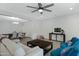 Open-concept living room with a ceiling fan, modern furniture, and a view into the dining area at 4417 N 156Th Dr, Goodyear, AZ 85395