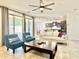 Inviting living room showcasing a comfortable sofa, blue chairs, ceiling fan, and open layout to kitchen at 4417 N 156Th Dr, Goodyear, AZ 85395