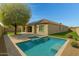 Inviting backyard pool with travertine tile decking, solar panels, and desert landscaping creates a relaxing outdoor oasis at 4417 N 156Th Dr, Goodyear, AZ 85395
