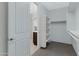 Large walk-in closet with built-in shelving, hanging rods and access to the bathroom at 4417 N 156Th Dr, Goodyear, AZ 85395