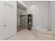 Elegant bathroom featuring a glass-enclosed shower, soaking tub with marble surround, and a storage cabinet at 4901 E Lafayette Blvd, Phoenix, AZ 85018