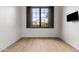 Bright empty bedroom featuring hardwood floors, a large window with mountain view, and TV at 4901 E Lafayette Blvd, Phoenix, AZ 85018