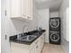 Functional laundry room with stacked washer and dryer, cabinets, a sink, and a modern faucet at 4901 E Lafayette Blvd, Phoenix, AZ 85018