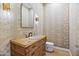 Quaint powder room with patterned wallpaper, a unique wood vanity, and a decorative mirror at 4901 E Lafayette Blvd, Phoenix, AZ 85018