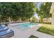 Backyard pool area featuring lounge chairs, landscaping, and mature trees at 4901 E Lafayette Blvd, Phoenix, AZ 85018