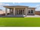 Lush backyard with artificial turf, covered patio, and low-maintenance landscaping at 5619 N 193Rd Ave, Litchfield Park, AZ 85340
