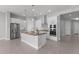 Well-lit kitchen with stainless steel appliances, white cabinets, and a center island at 5619 N 193Rd Ave, Litchfield Park, AZ 85340