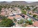 Sweeping aerial view of Southwestern homes with red tile roofs, landscaped yards, and a mountain backdrop under a bright sky at 5959 W Lone Cactus Dr, Glendale, AZ 85308