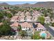 Expansive aerial view of a neighborhood featuring Southwestern homes, lush greenery, pools, and desert landscaping at 5959 W Lone Cactus Dr, Glendale, AZ 85308