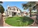 Expansive backyard features a play area and patio with a lush lawn and mature trees at 5959 W Lone Cactus Dr, Glendale, AZ 85308