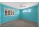 Bright bedroom with a ceiling fan, large window, and fresh turquoise paint at 5959 W Lone Cactus Dr, Glendale, AZ 85308