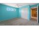 Turquoise bedroom with three small windows, fresh paint and built-in storage cabinets at 5959 W Lone Cactus Dr, Glendale, AZ 85308