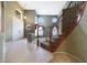 Welcoming foyer featuring tile flooring and a wooden staircase with decorative wrought iron at 5959 W Lone Cactus Dr, Glendale, AZ 85308