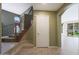 Inviting foyer with staircase, neutral tile flooring, storage closet and an arched entryway to the main living area at 5959 W Lone Cactus Dr, Glendale, AZ 85308