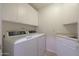 Laundry room with white cabinets, modern appliances, and tiled floors at 5959 W Lone Cactus Dr, Glendale, AZ 85308