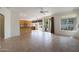 Open-concept living area with tile flooring, a ceiling fan, a sliding glass door, and a partial view of the kitchen at 5959 W Lone Cactus Dr, Glendale, AZ 85308