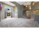 Bright, spacious living room with a tall ceiling, chandelier, and wrought iron staircase at 5959 W Lone Cactus Dr, Glendale, AZ 85308