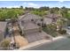 Stunning aerial view of a tan two-story home with a three-car garage, manicured lawn, and a private backyard at 630 S Boulder Ct, Gilbert, AZ 85296