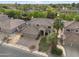 Expansive aerial view of a tan two-story house with a three-car garage, palm trees and a well-maintained lawn at 630 S Boulder Ct, Gilbert, AZ 85296