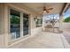 A covered patio includes a ceiling fan, and space for grilling with a large patio space outside sliding glass doors at 630 S Boulder Ct, Gilbert, AZ 85296