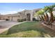 Inviting two-story home boasts a well-manicured lawn, lush palm trees, and a spacious three-car garage at 630 S Boulder Ct, Gilbert, AZ 85296