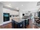 The kitchen has stainless appliances, granite counters and a center island with seating that overlooks the living room at 630 S Boulder Ct, Gilbert, AZ 85296