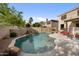 Backyard pool with waterfall feature, desert landscaping, and an orange cushioned outdoor seating area at 630 S Boulder Ct, Gilbert, AZ 85296