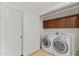 Bright laundry room features a washer, dryer, brown cabinets, and white doors at 6803 E Main St # 1106, Scottsdale, AZ 85251